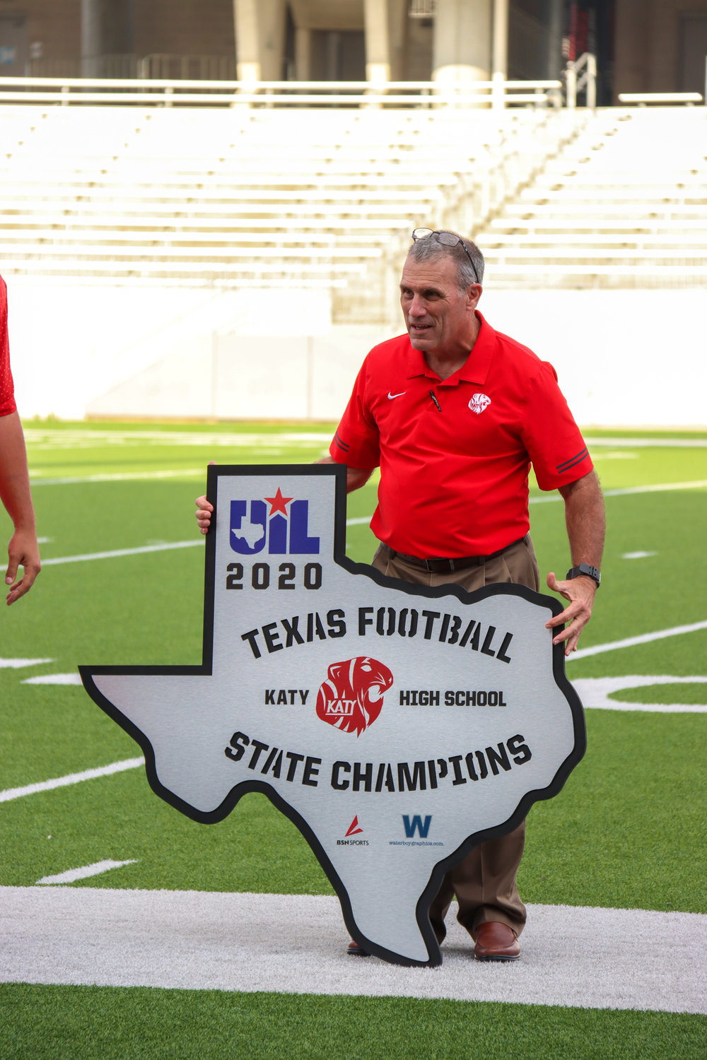 Katy coach Gary Joseph holds a 2020 state championship sign awarded to the program on behalf of BSN Sports.